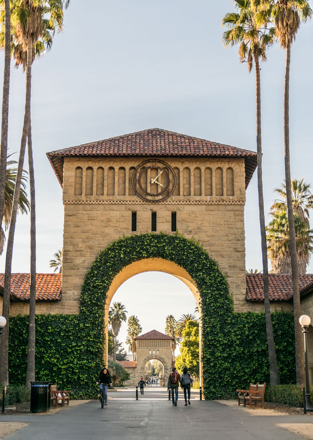 Stone archway with clock covered in ivy at Stanford University