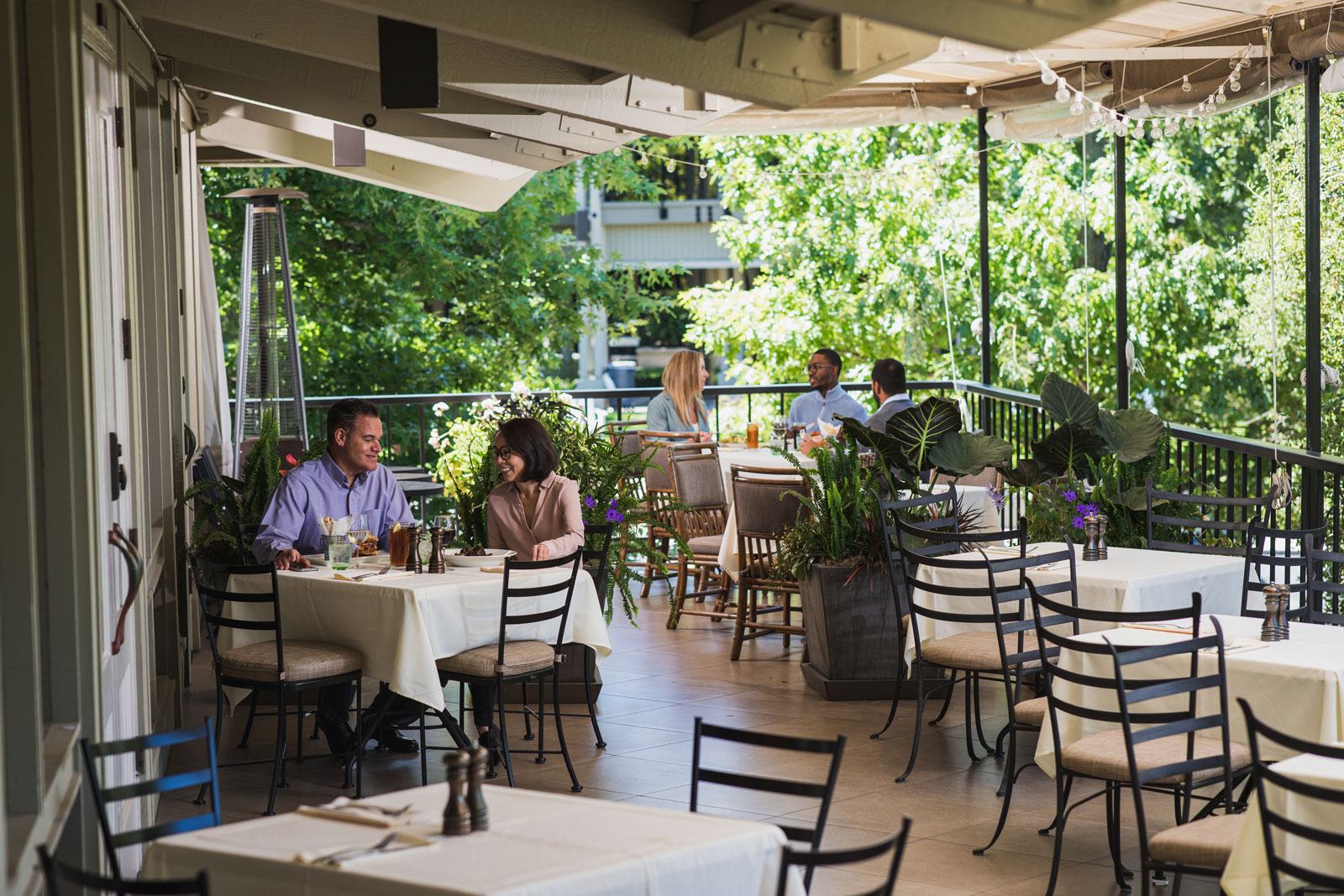 Patrons enjoy the outdoor patio balcony of a restaurant