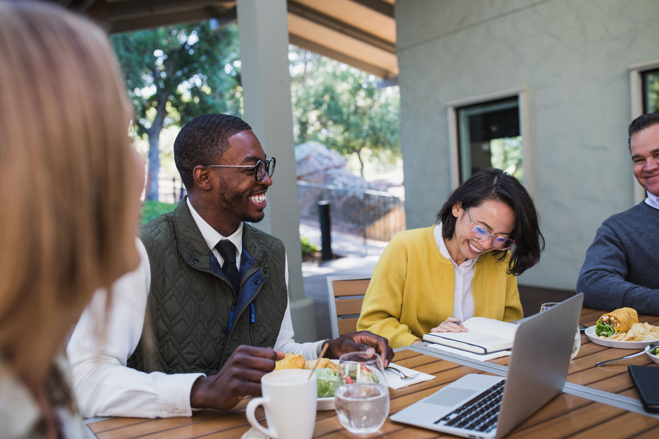 A group of colleagues laugh during a working lunch