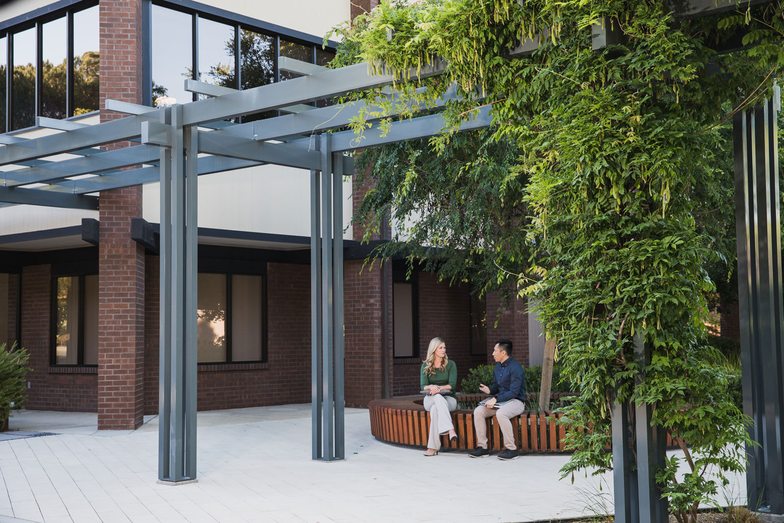 Two colleagues talk together ouside the building
